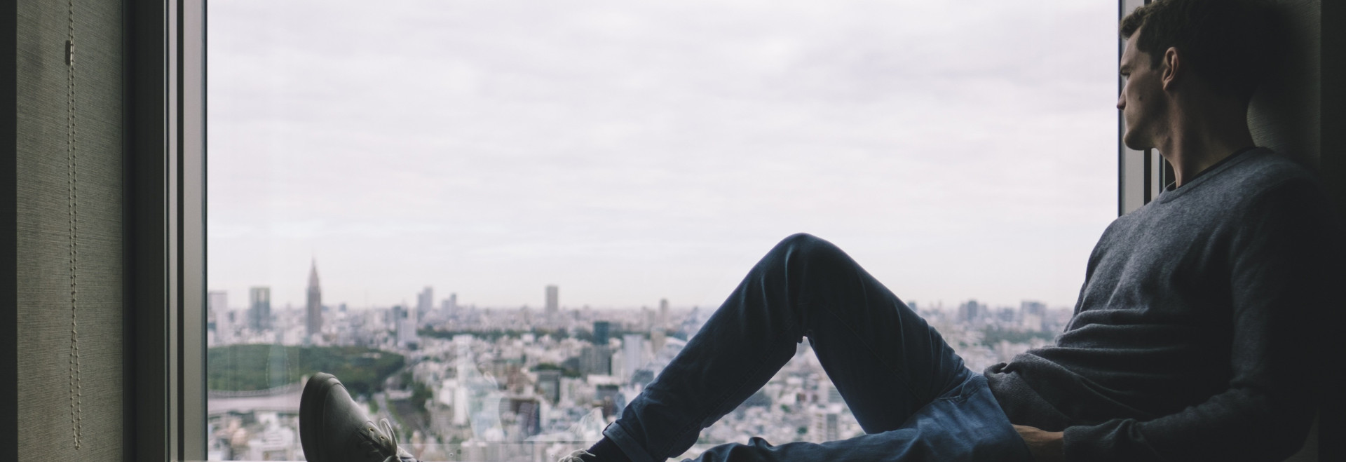 Foto eines Mannes der entspannt aus dem Fenster schaut