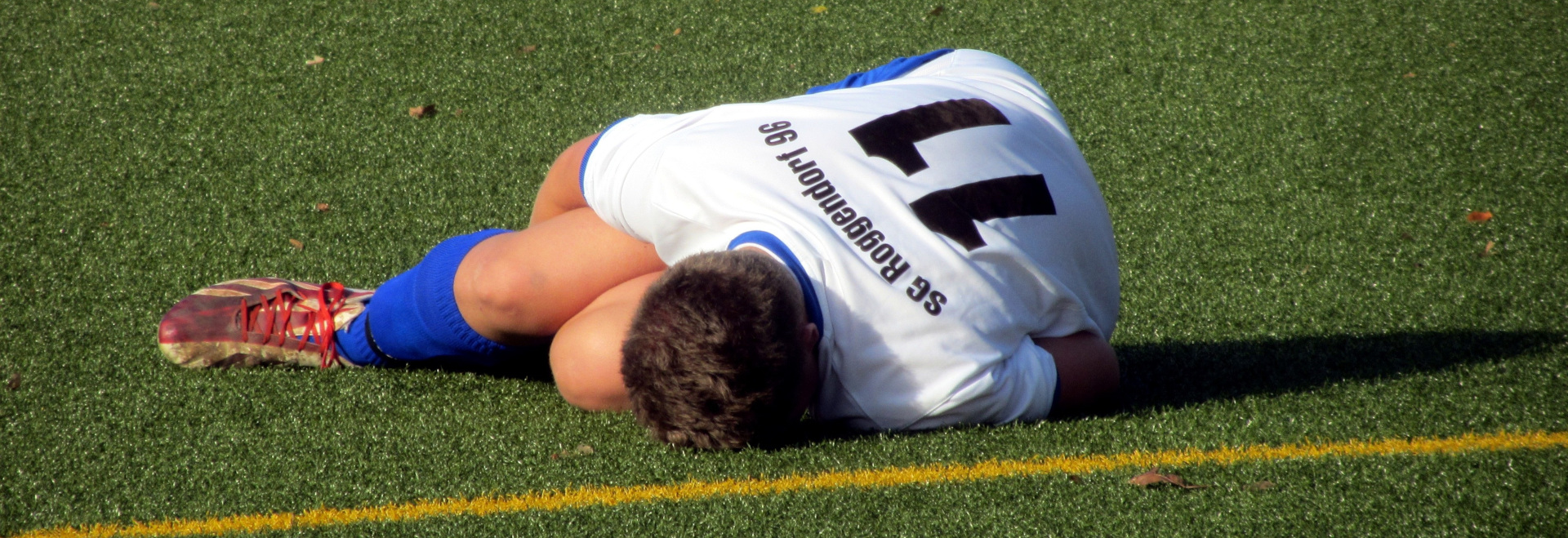 Foto eines verletzten Fussballers auf dem Rasen